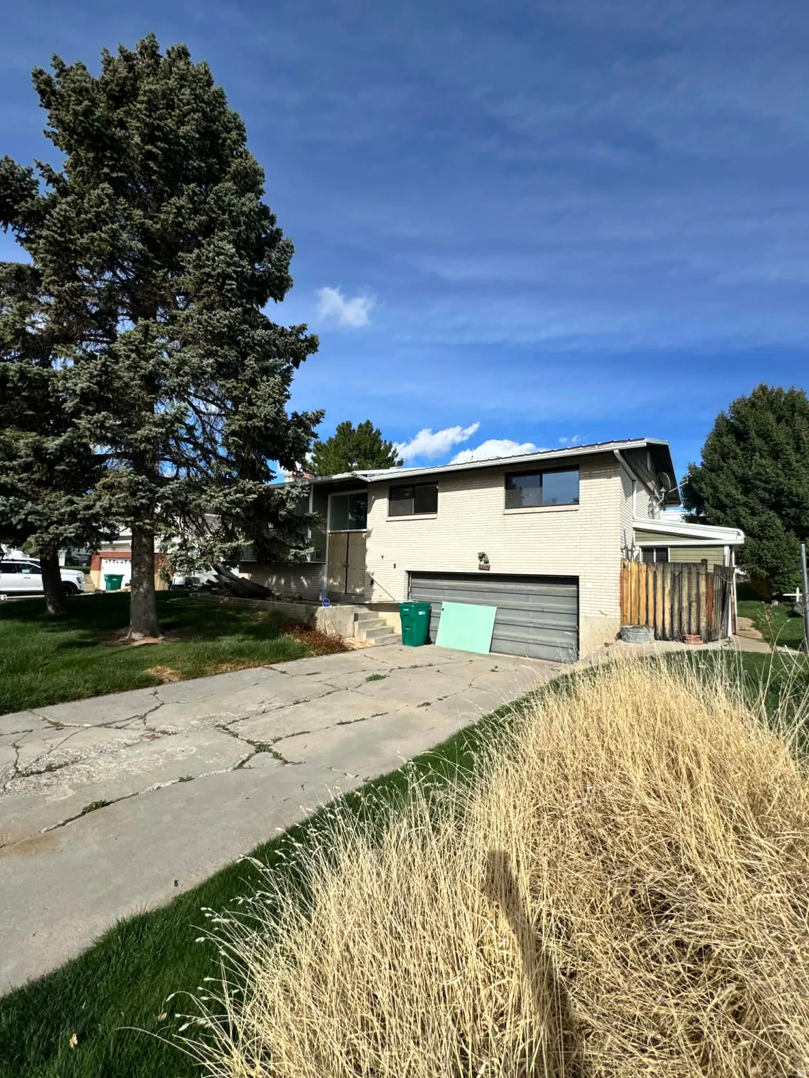 View of front of home with a garage, concrete driveway, and a patio area