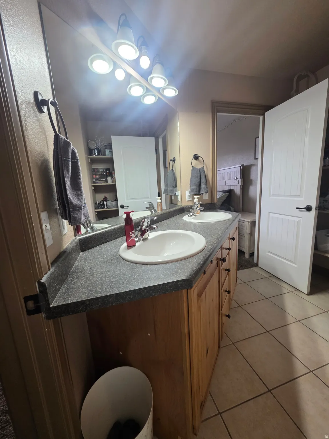 Full bathroom featuring double vanity and light tile patterned flooring