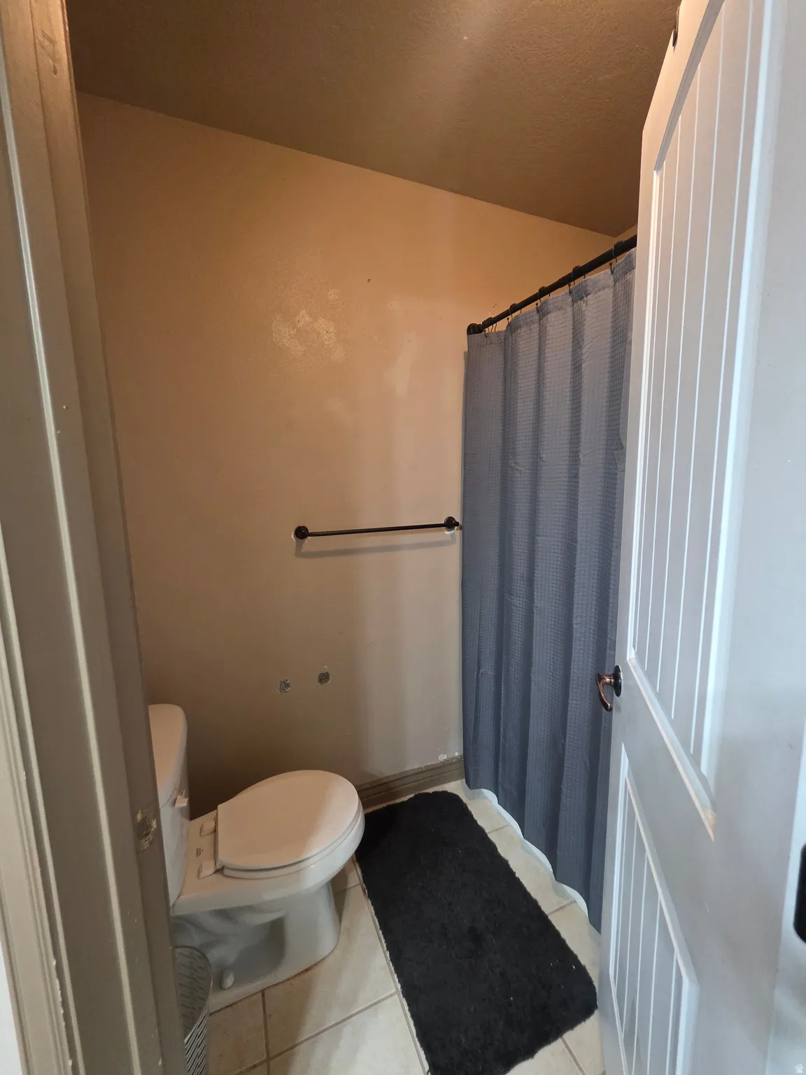 Bathroom featuring a shower with curtain and light tile patterned floors