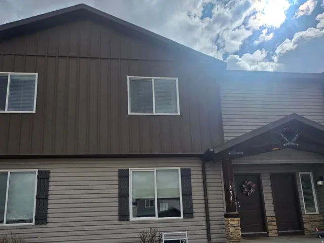 View of front of home featuring a front yard, board and batten siding, and a porch