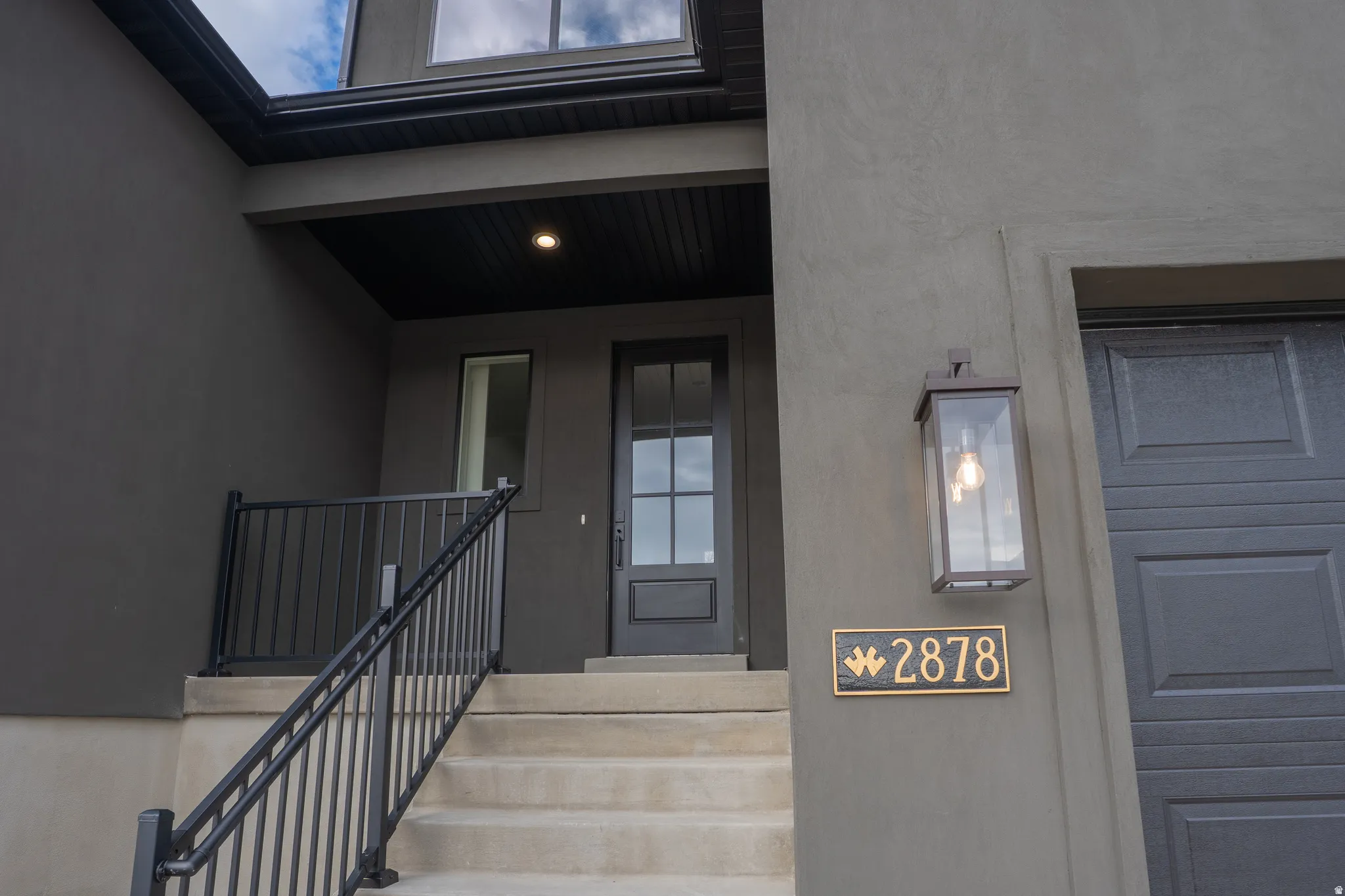 Property entrance with stucco siding and covered porch