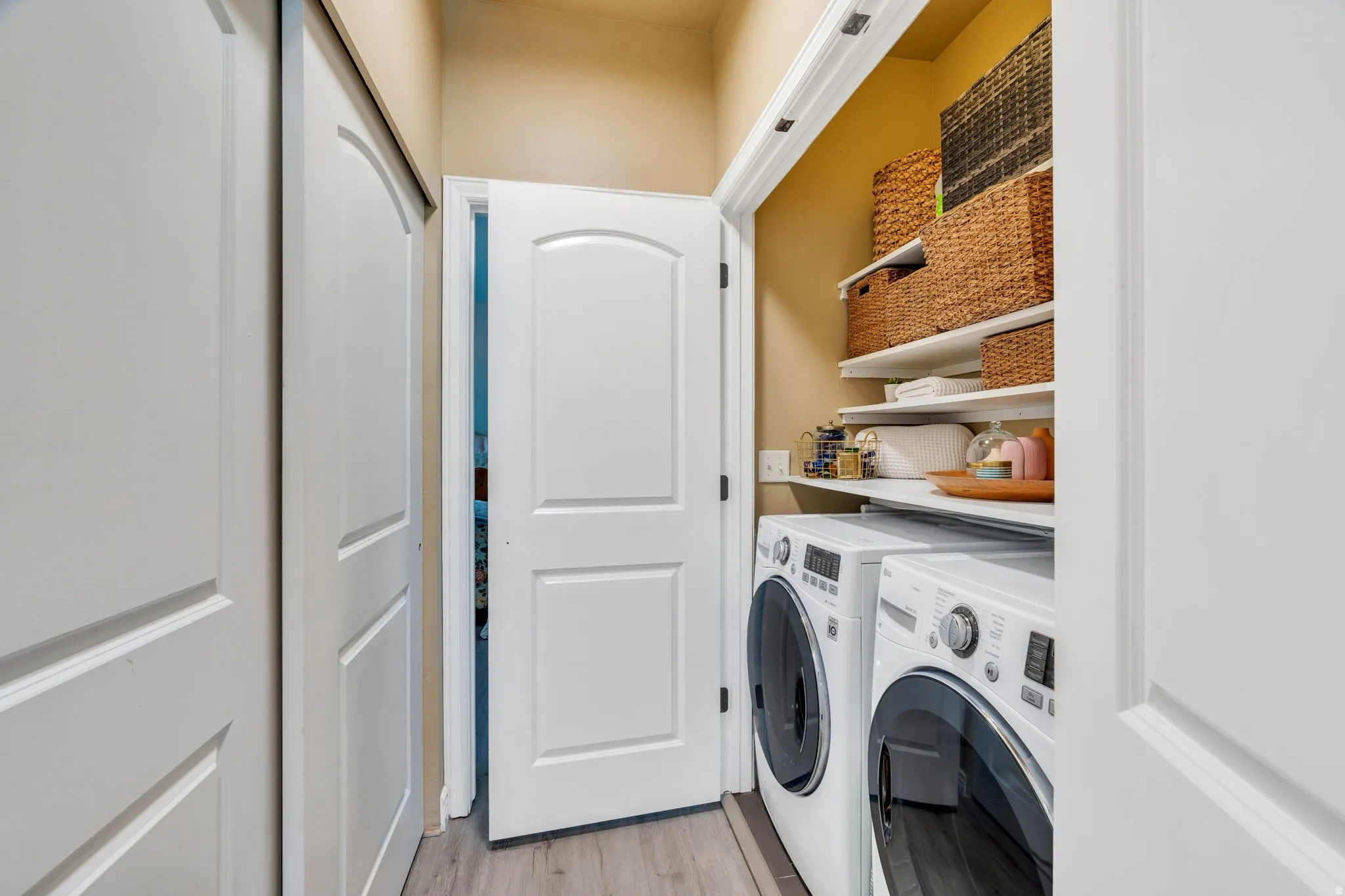 Laundry area featuring light wood-type flooring and separate washer and dryer