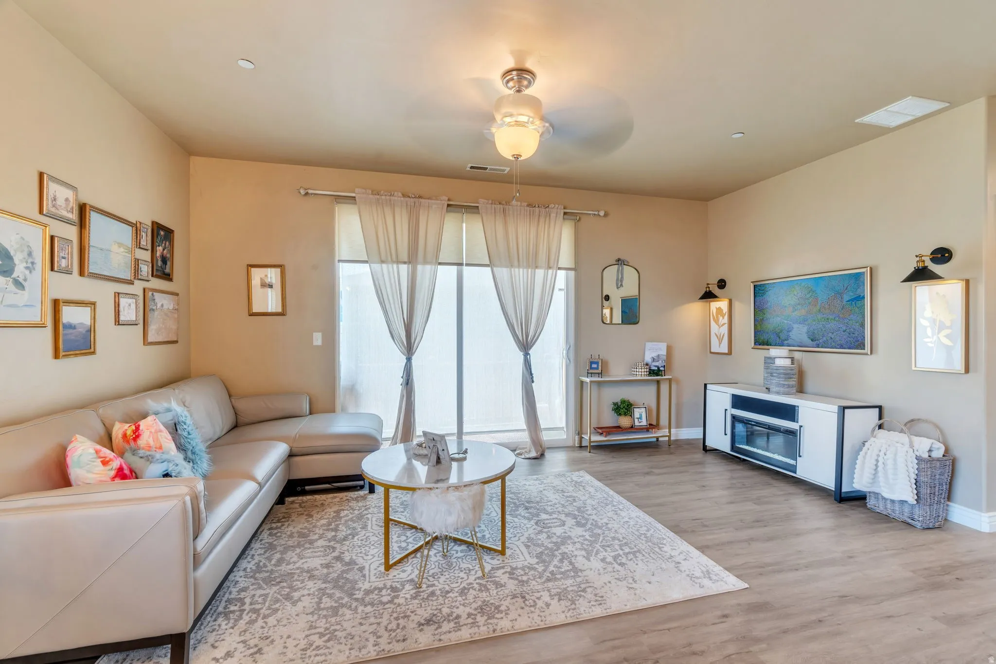 Living area featuring light wood-style floors and a ceiling fan