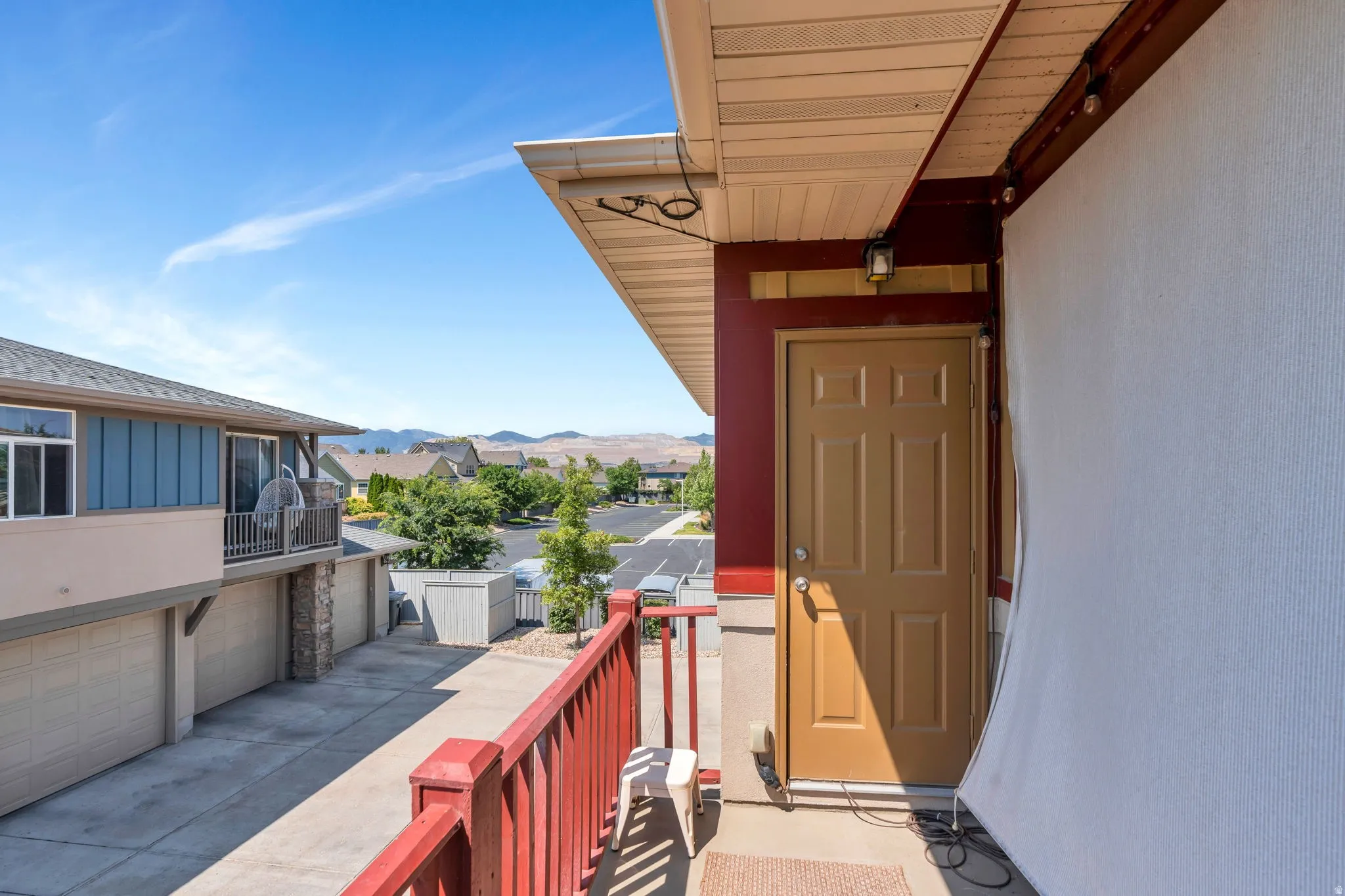View of exterior entry with concrete driveway, a mountain view, a garage, stucco siding, and a residential view