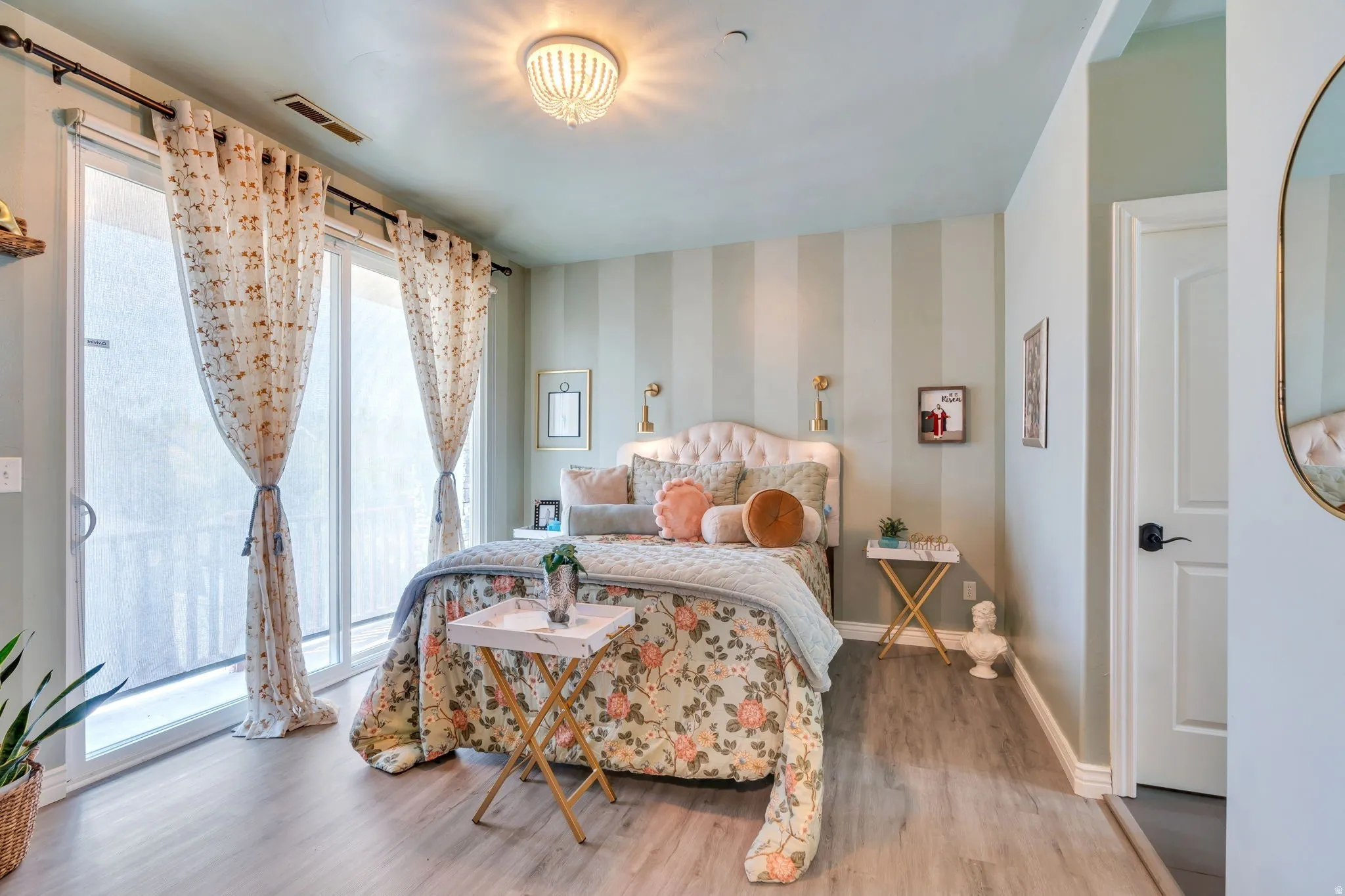 Bedroom with light wood finished floors and wallpapered walls