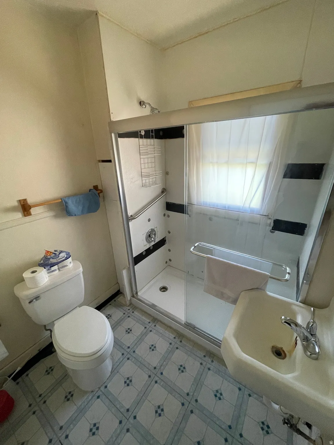 Bathroom featuring light floors and a shower stall