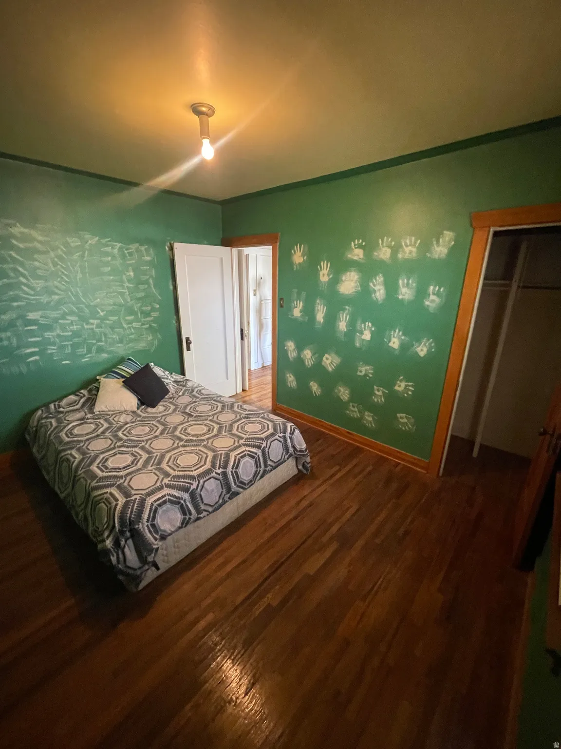 Bedroom with dark wood finished floors and baseboards