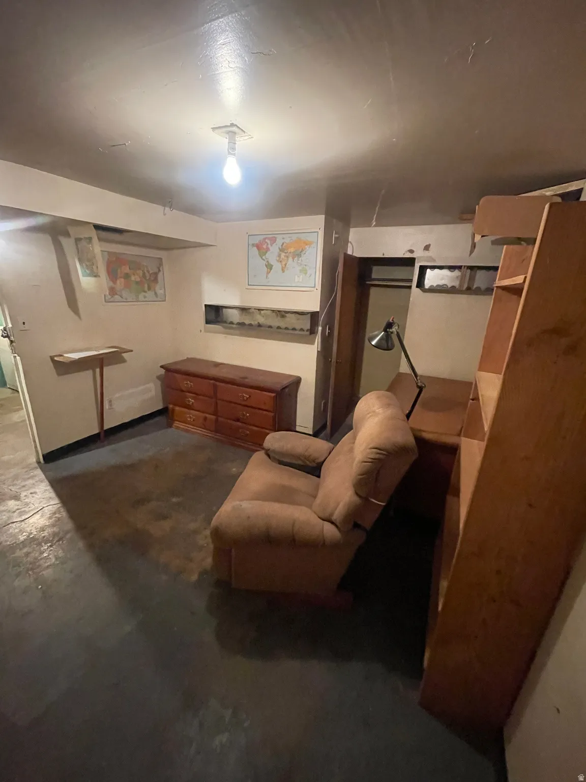 Basement bedroom with unfinished concrete floors