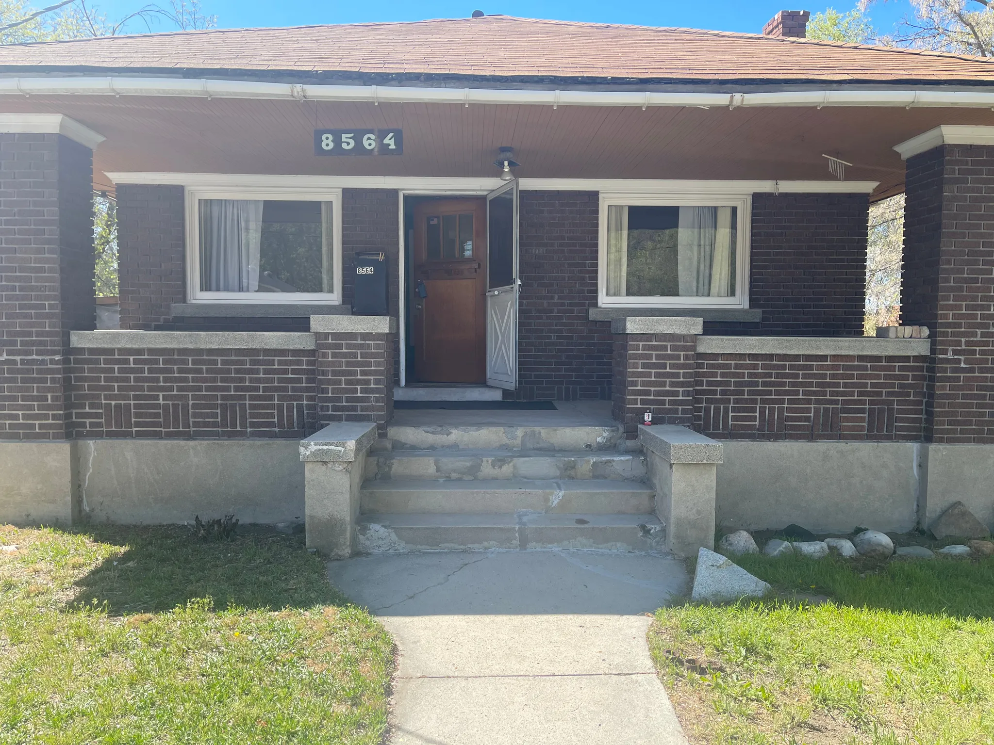 Property entrance with covered porch and brick siding