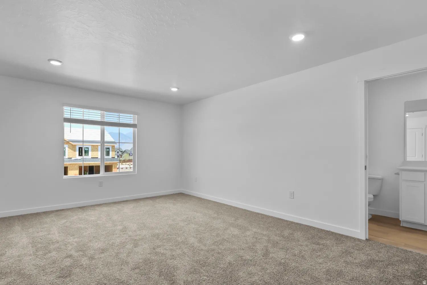 Empty room featuring light colored carpet and recessed lighting