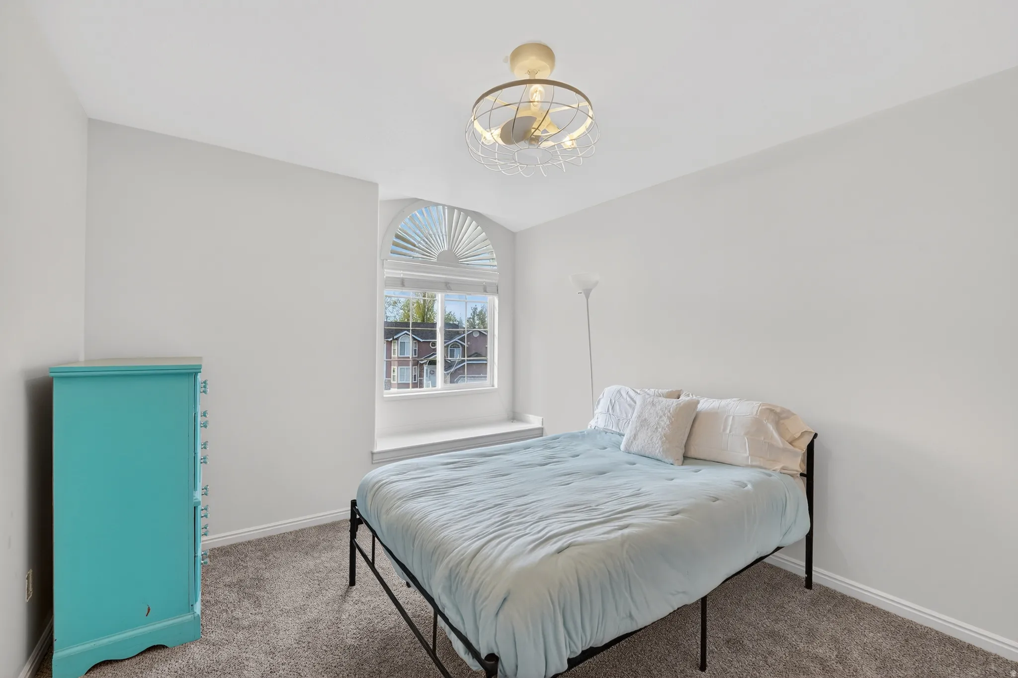 Carpeted bedroom with a chandelier and baseboards