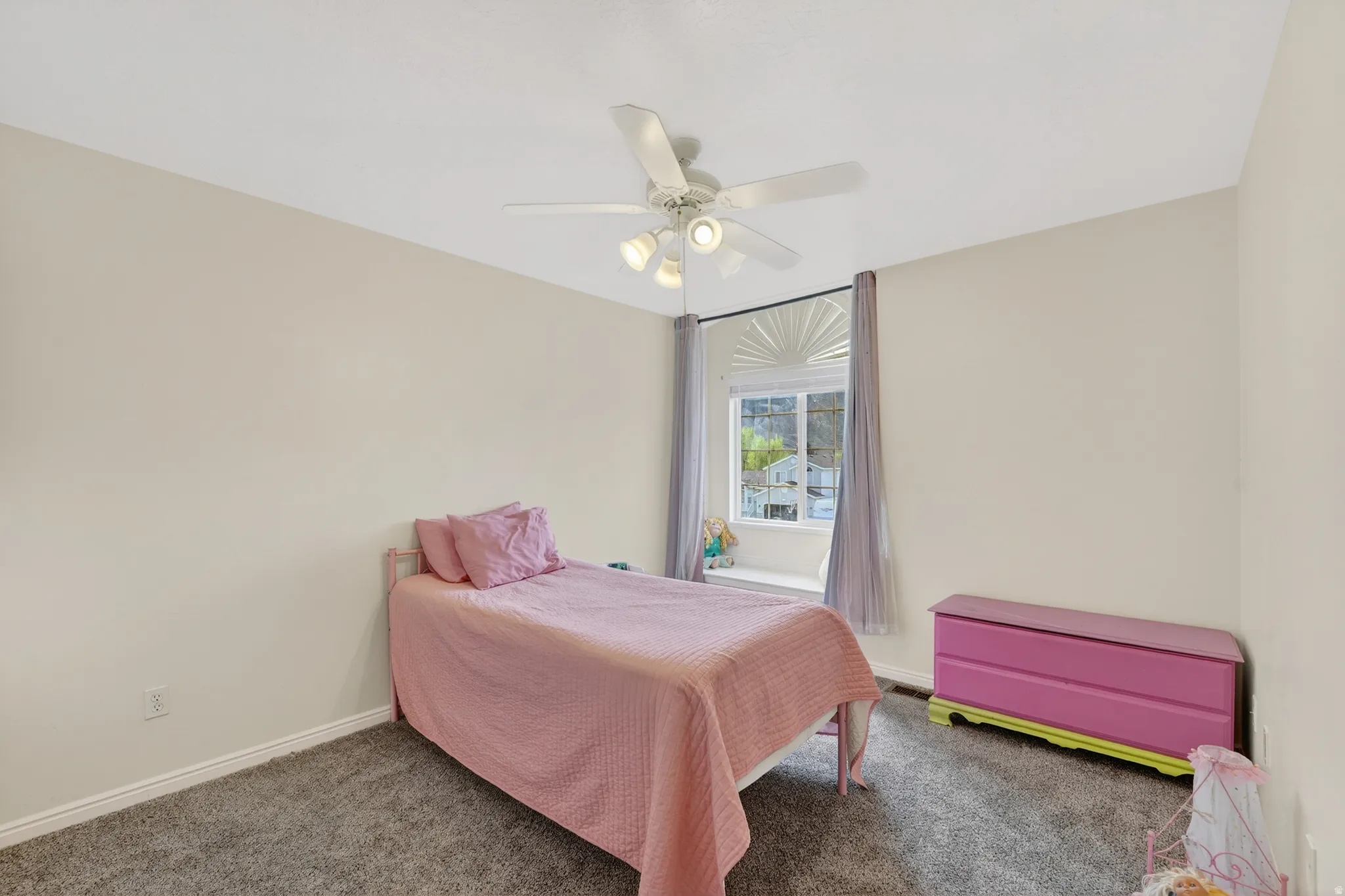 Bedroom with dark carpet and a ceiling fan