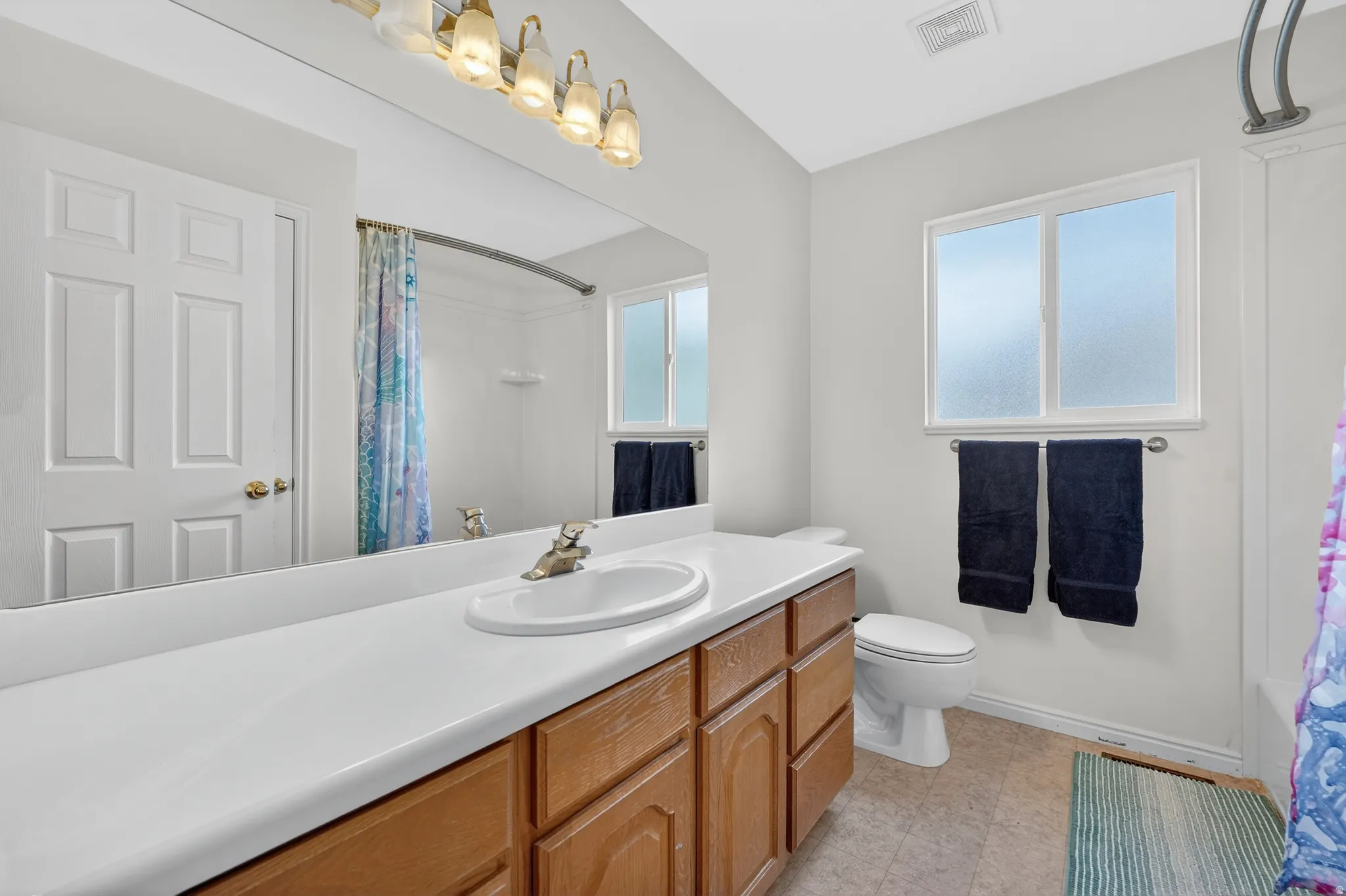 Full bath with vanity and shower / bath combo