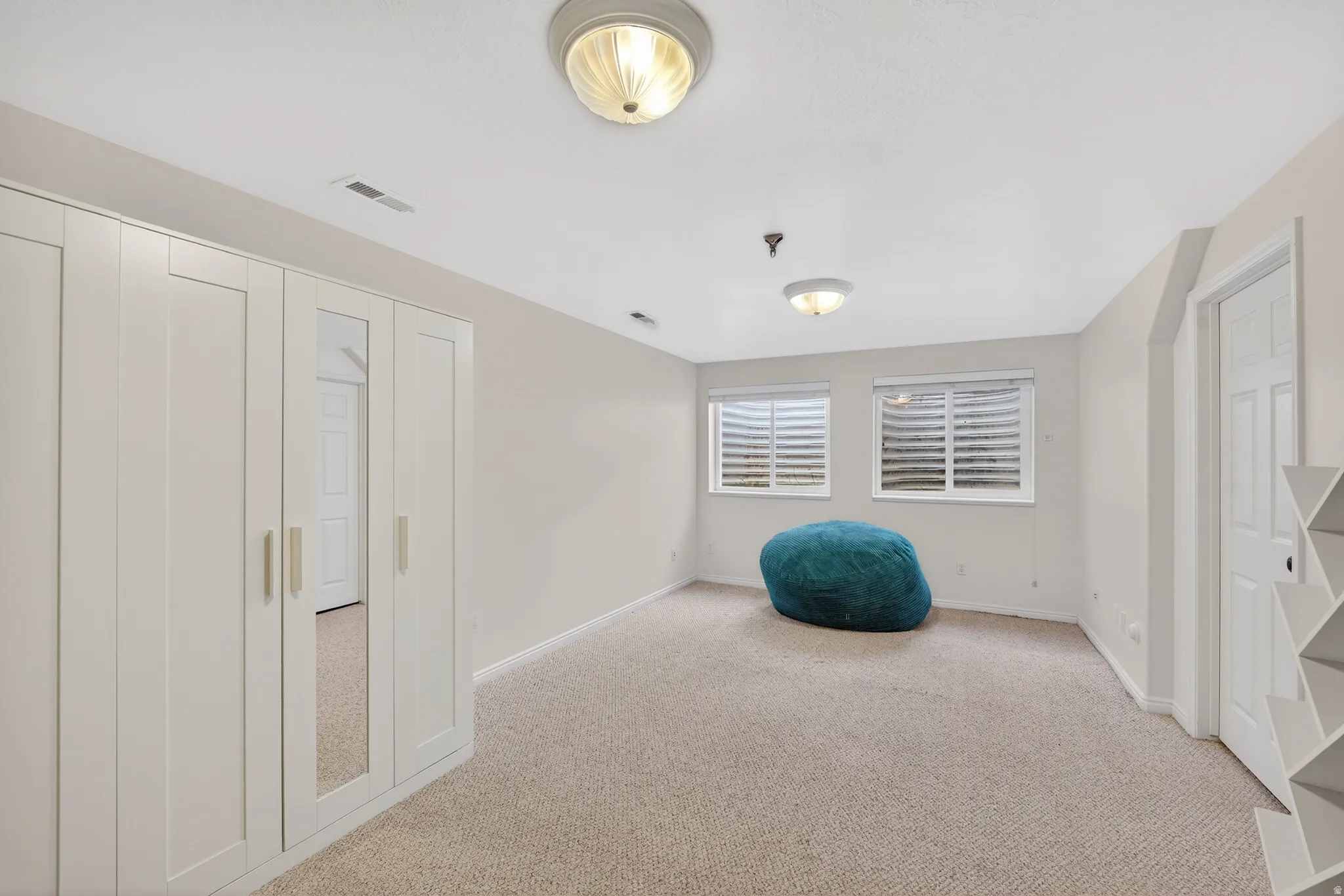 Unfurnished room featuring light carpet and baseboards
