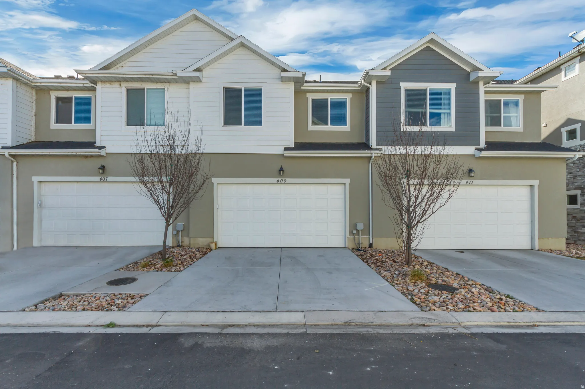 View of front of home featuring stucco siding, an attached garage, and driveway