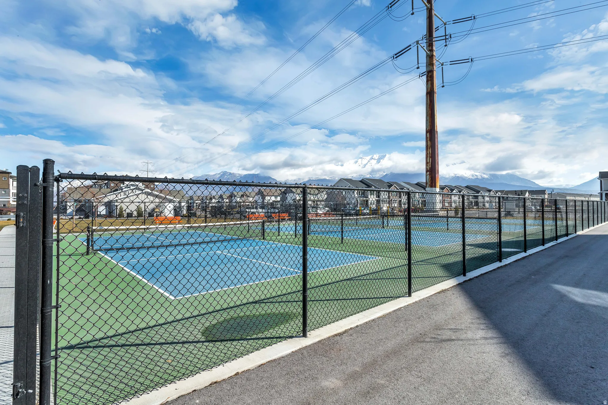 View of tennis court with a mountain view and a residential view