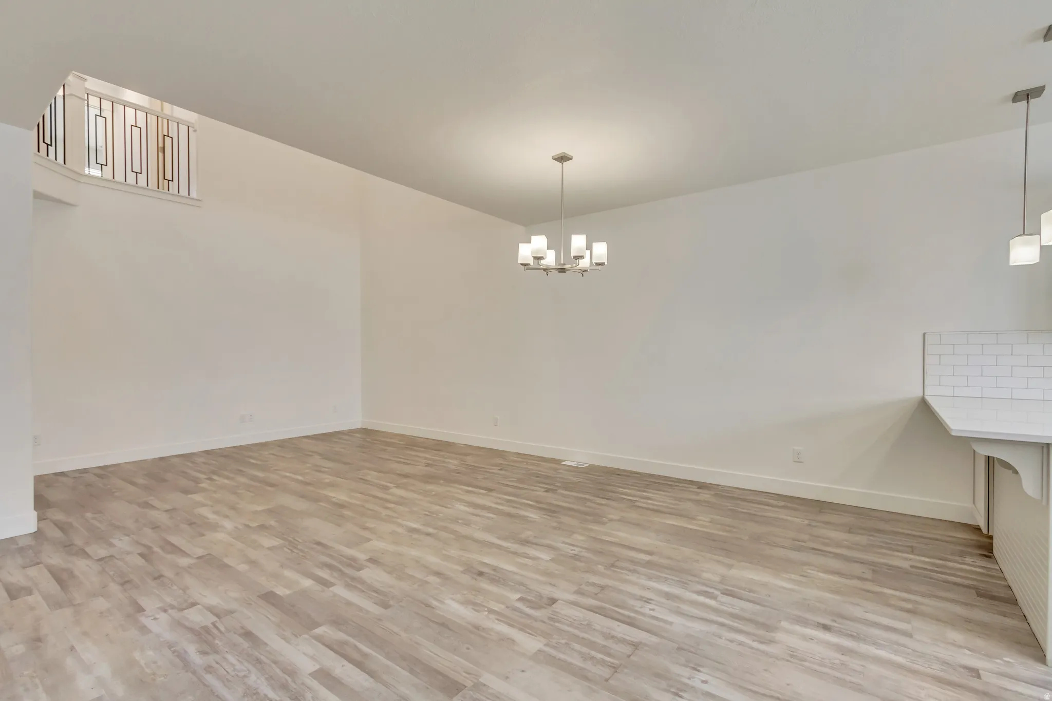 Unfurnished dining area featuring a chandelier and light wood-style flooring