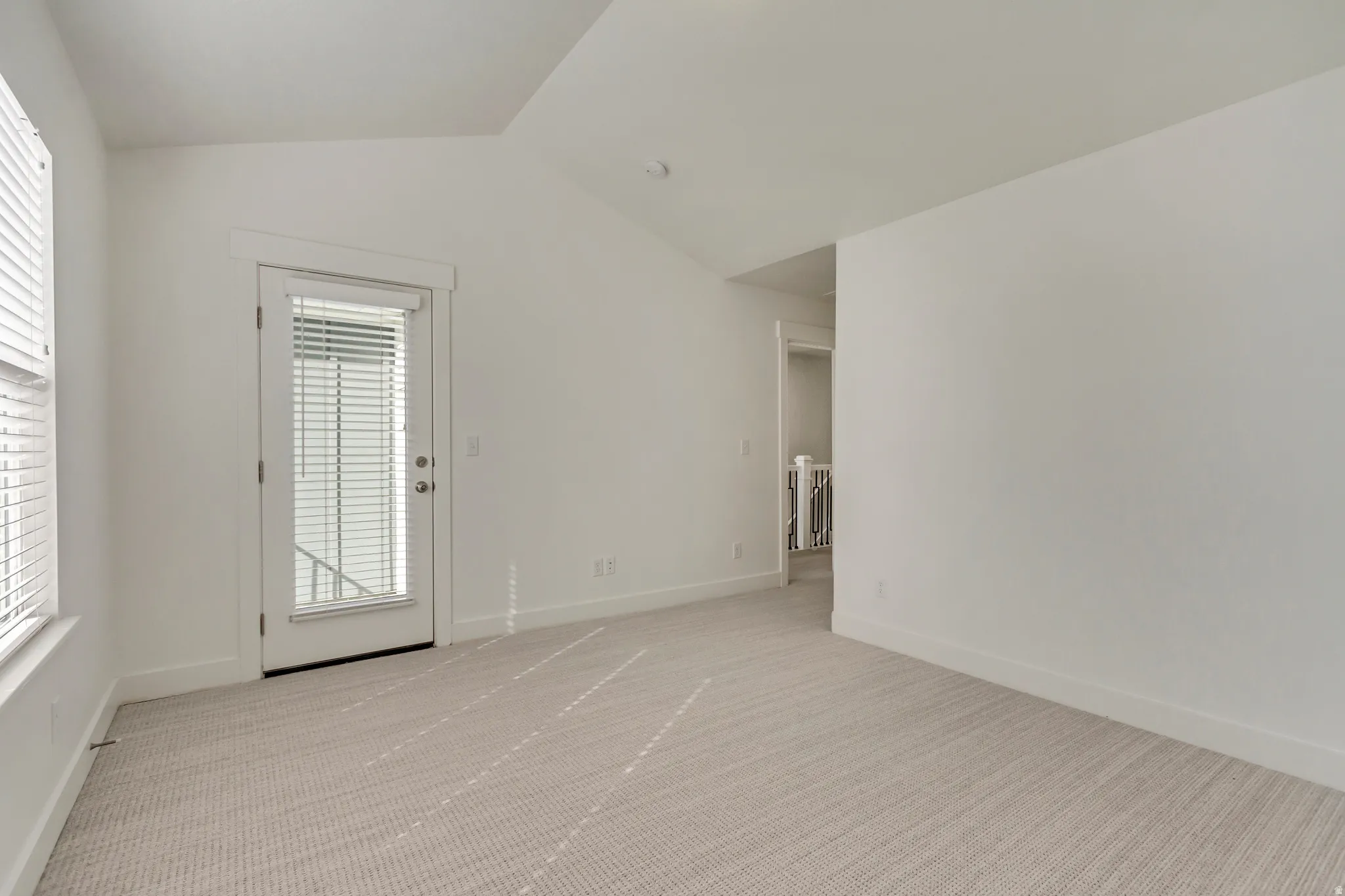 Spare room featuring light colored carpet and baseboards
