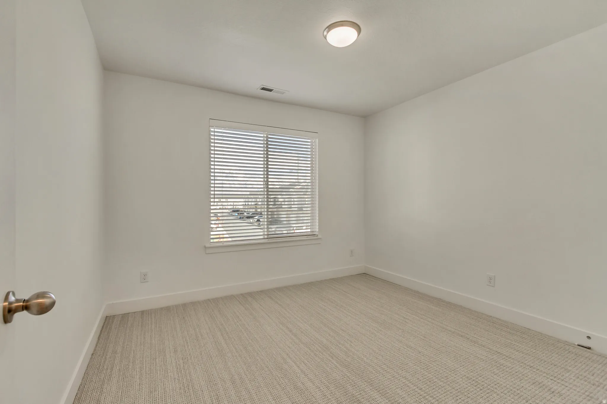 Empty room featuring light carpet and baseboards
