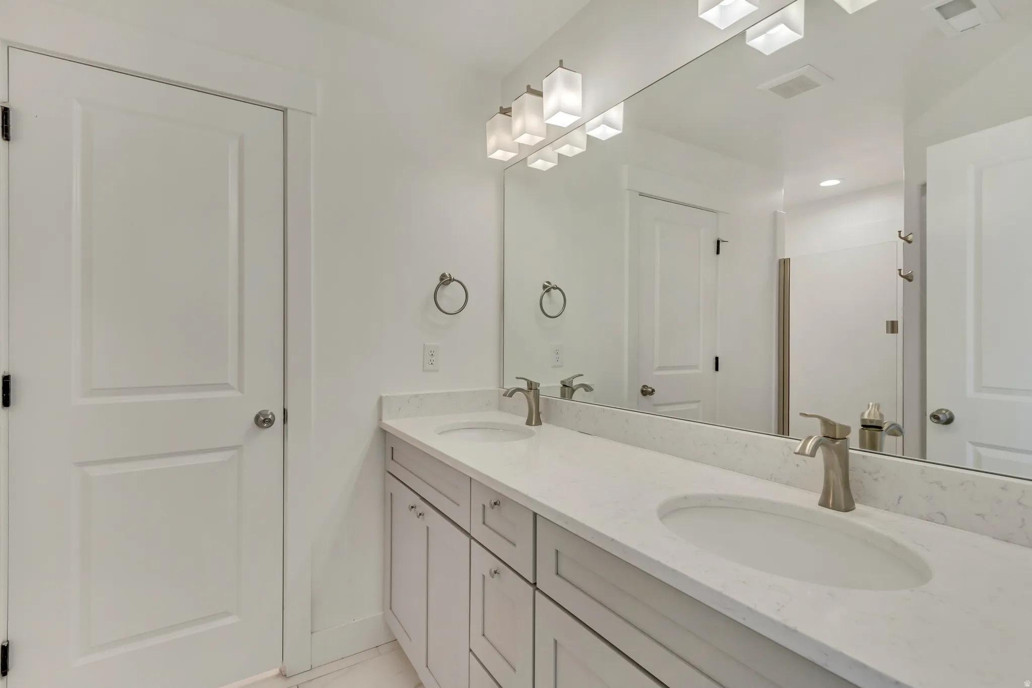 Full bath featuring double vanity and baseboards