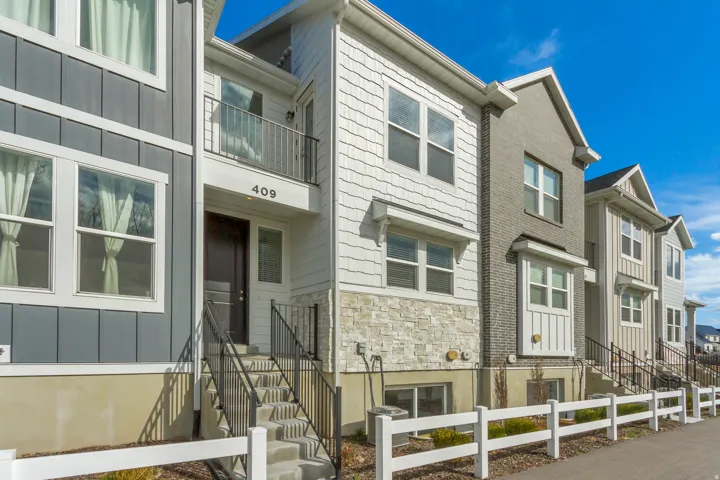 View of front of home featuring stone siding, a balcony, and board and batten siding