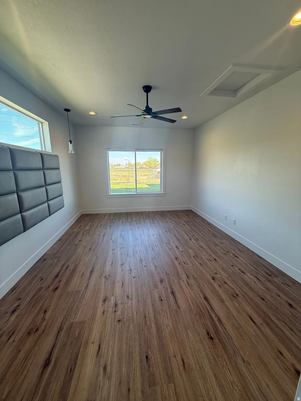 Empty room with dark wood-type flooring, a ceiling fan, and recessed lighting
