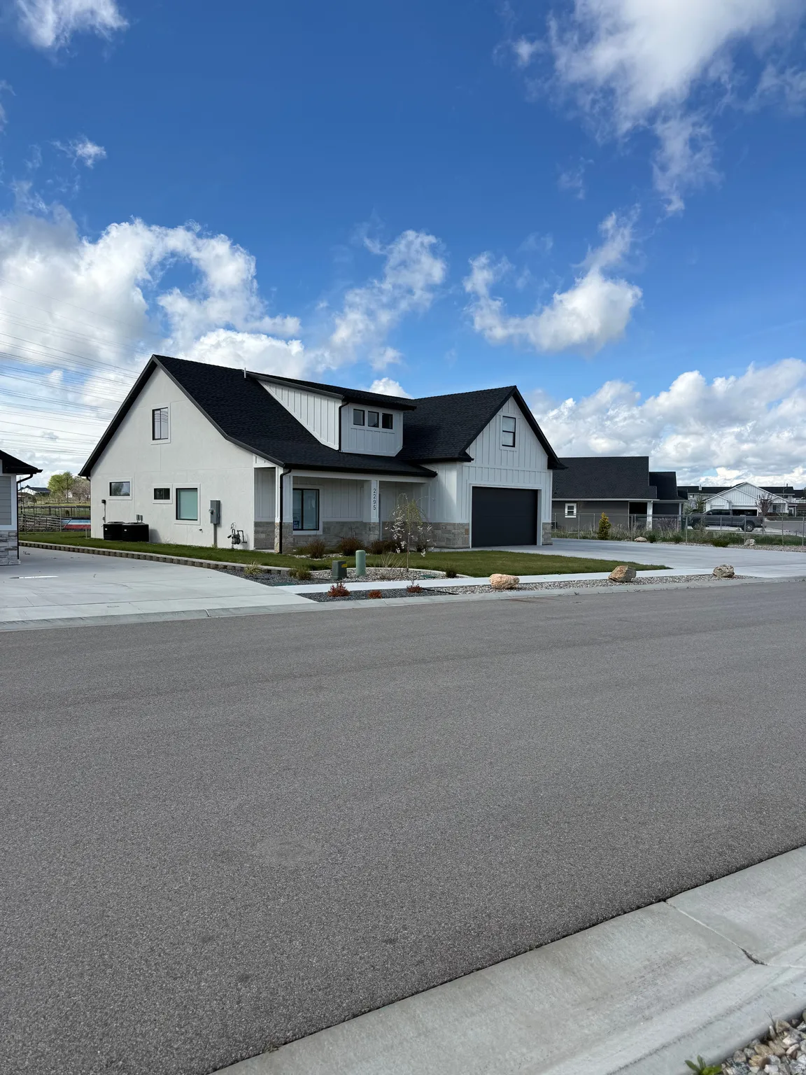 Modern farmhouse featuring board and batten siding, a garage, and covered porch