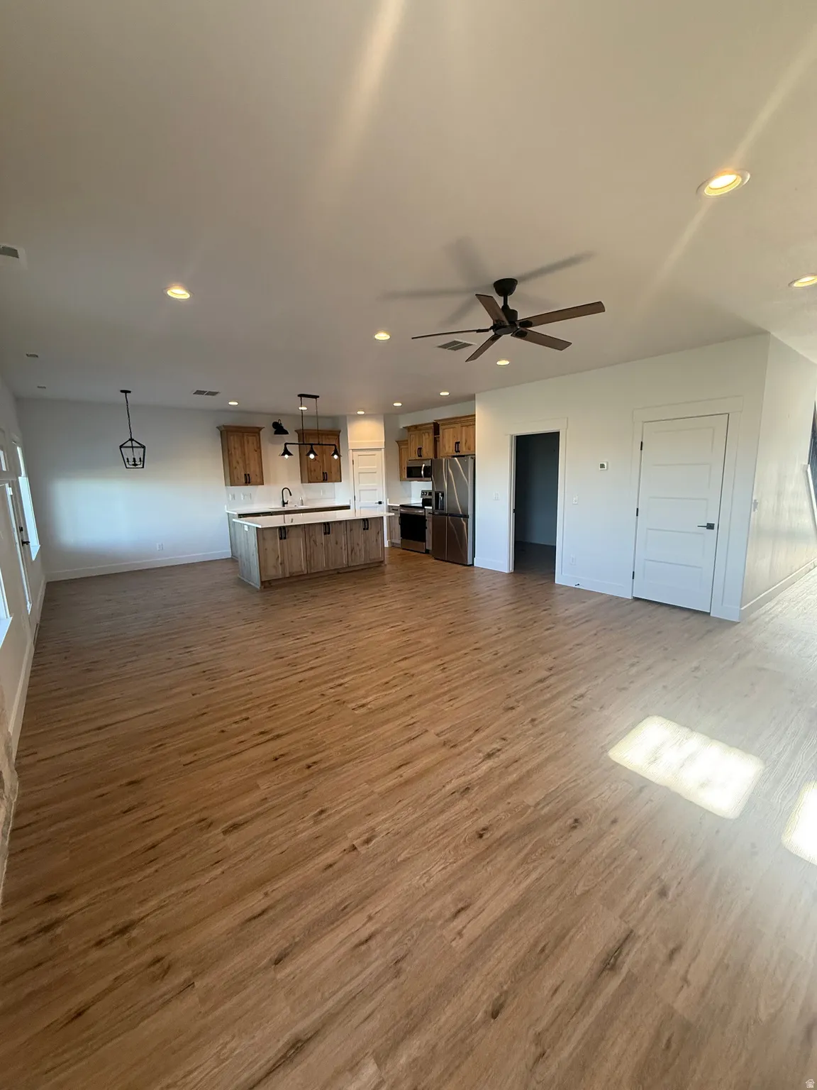 Unfurnished living room featuring dark wood finished floors, recessed lighting, and a ceiling fan
