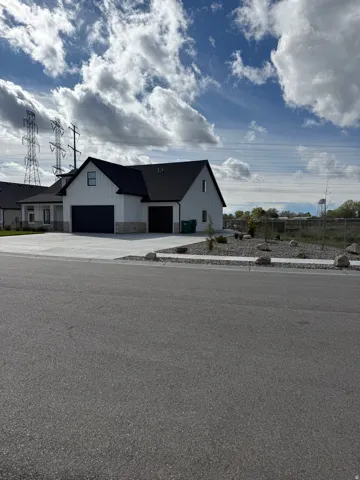 Modern farmhouse with stone siding, board and batten siding, and an attached garage