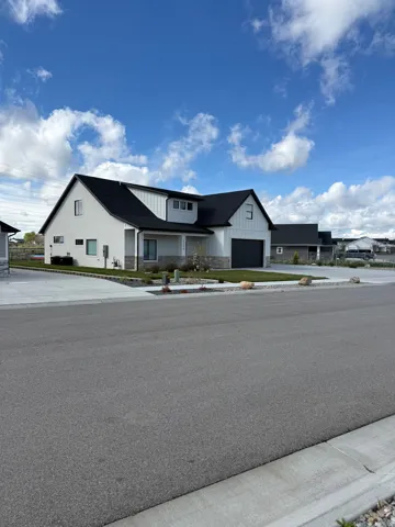 Modern farmhouse featuring board and batten siding, a garage, and covered porch