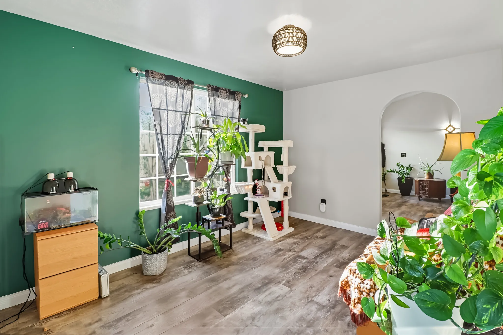 Nook of kitchen and living room featuring wood finished floors and arched walkways