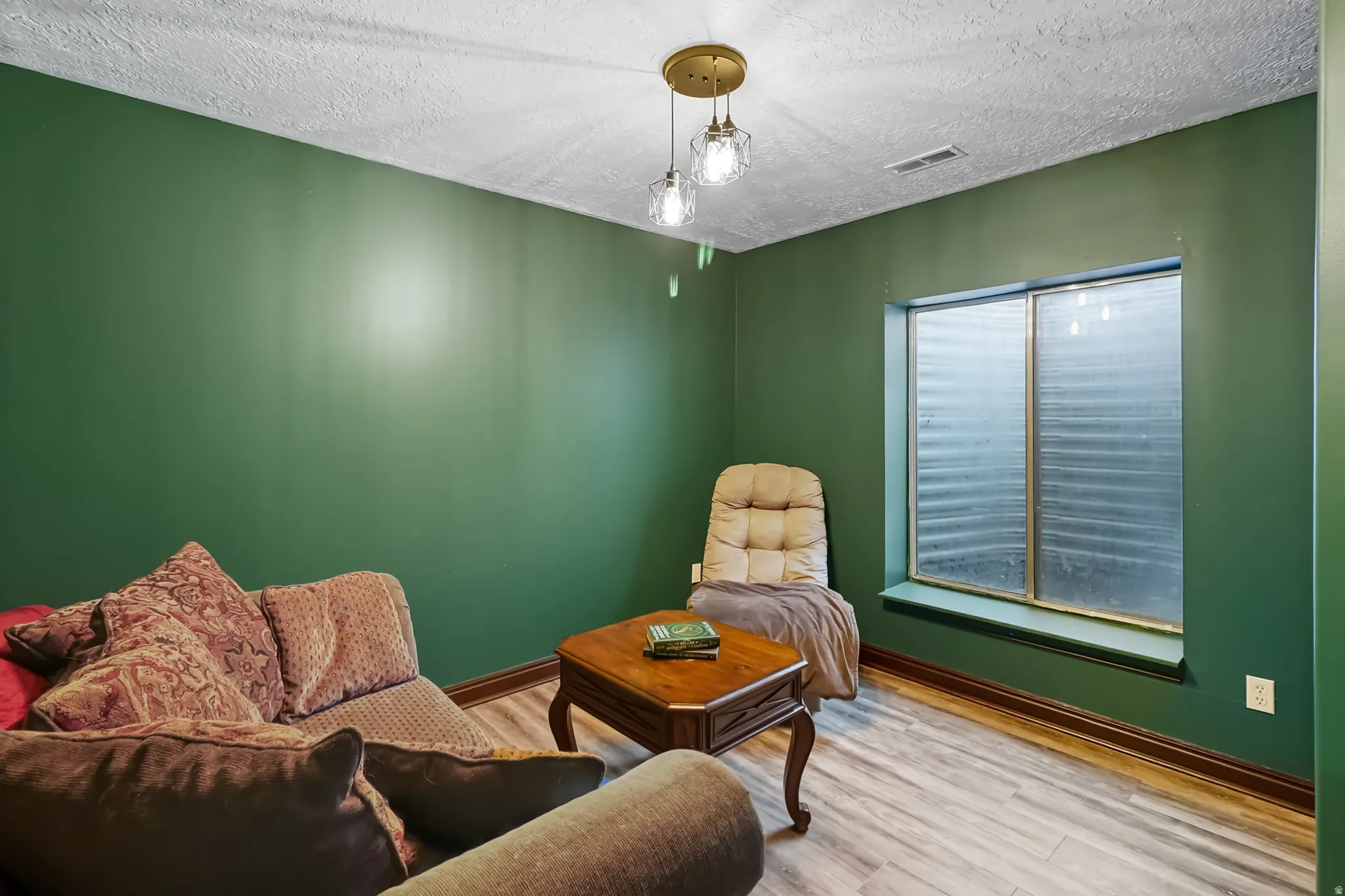 Basement bedroom with wood finished floors and a textured ceiling