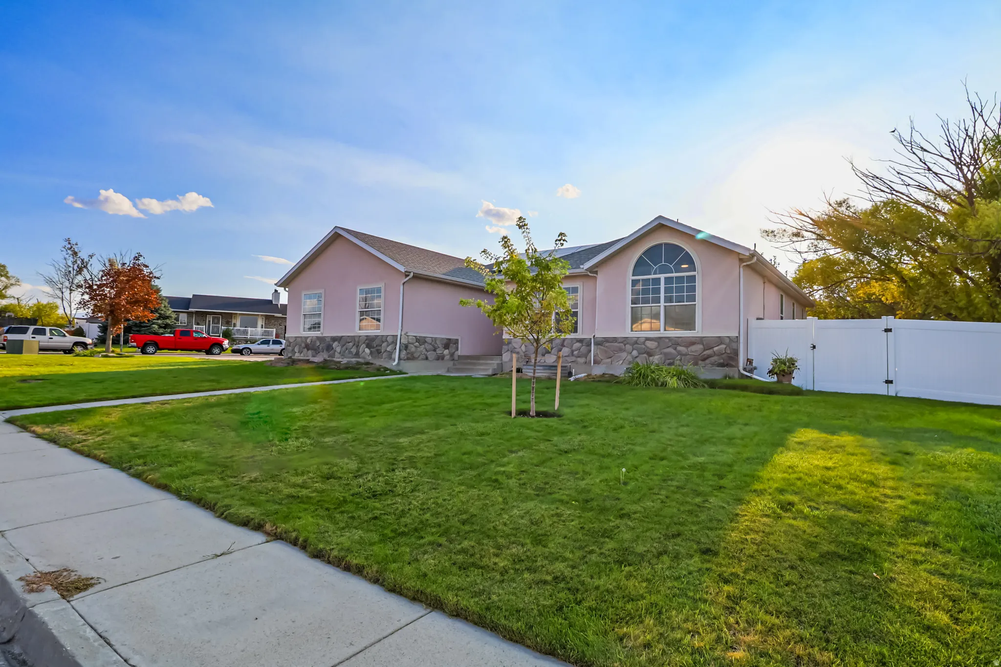 Rambler with a fully fenced yard and gate, stucco siding, and stone siding