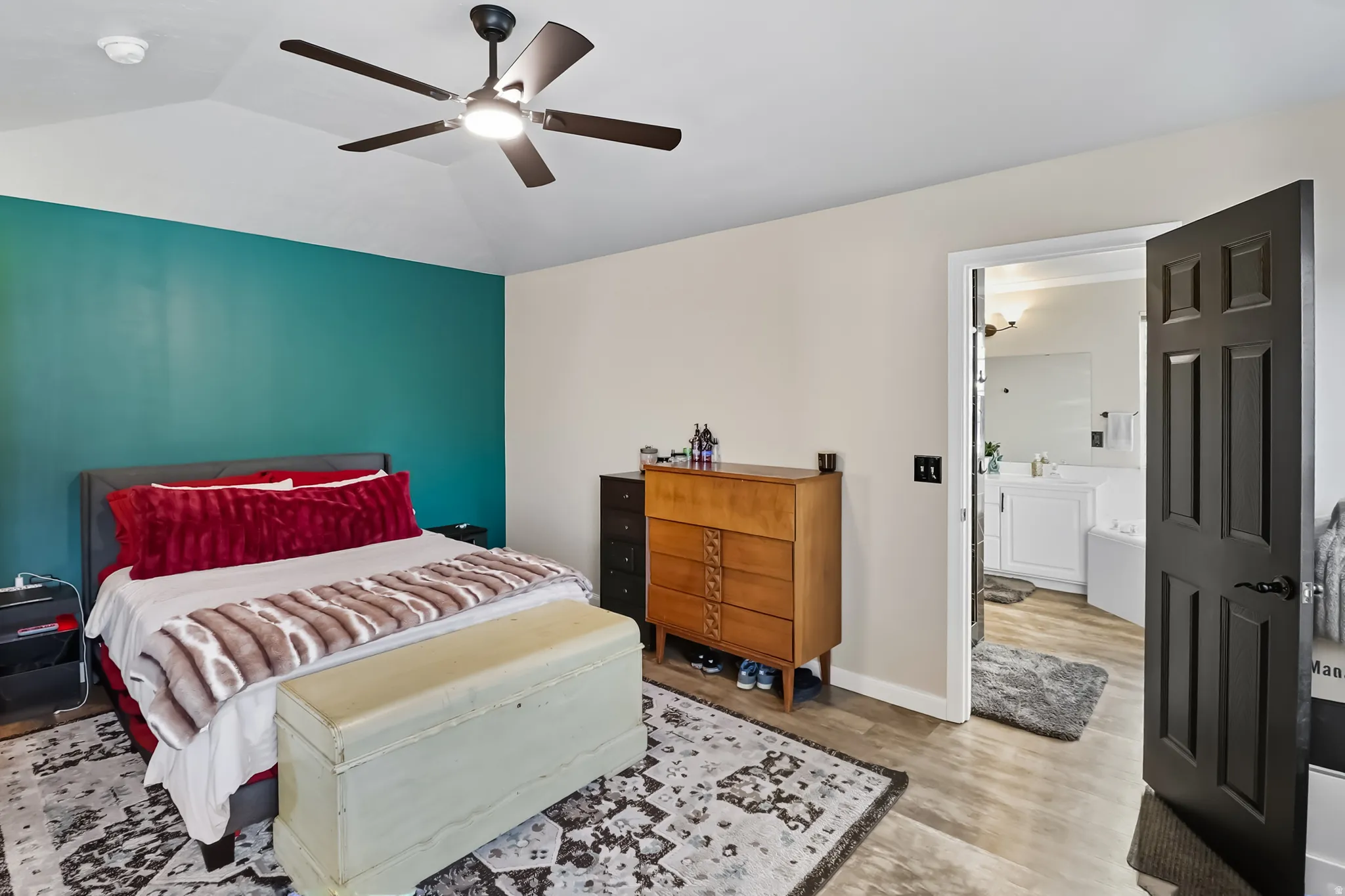 Bedroom featuring lofted ceiling, light wood-type flooring, and a ceiling fan