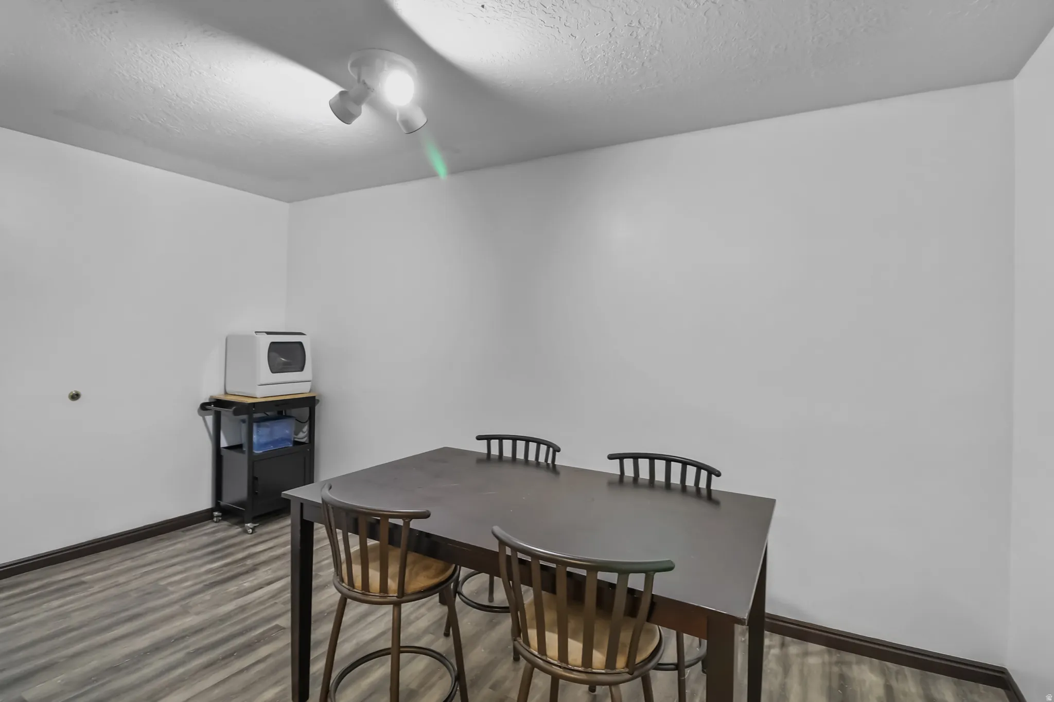 Basement dining area featuring a textured ceiling and wood finished floors