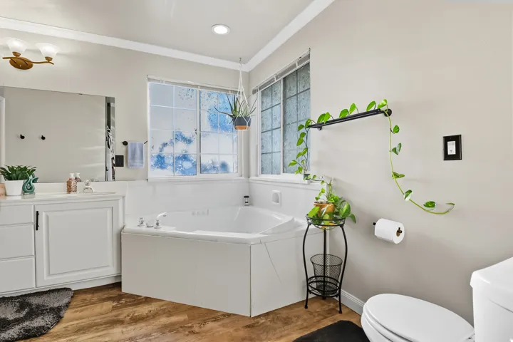 Master Bathroom - Full bath featuring a garden tub, vanity, crown molding, and light wood-type flooring