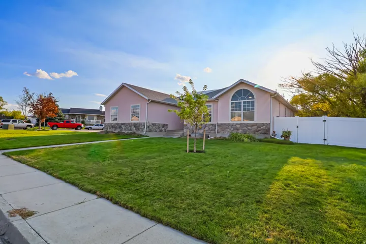 Rambler with a fully fenced yard and gate, stucco siding, and stone siding