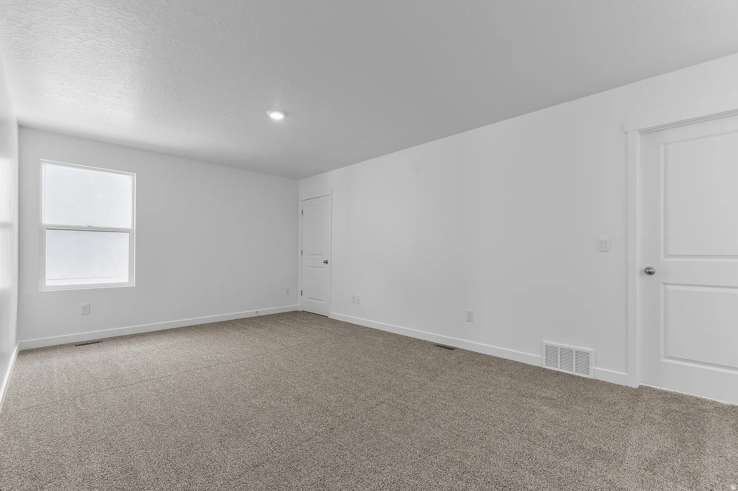Carpeted spare room featuring baseboards