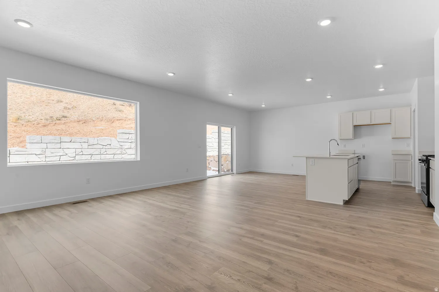 Unfurnished living room featuring light wood-style flooring, recessed lighting, and a textured ceiling