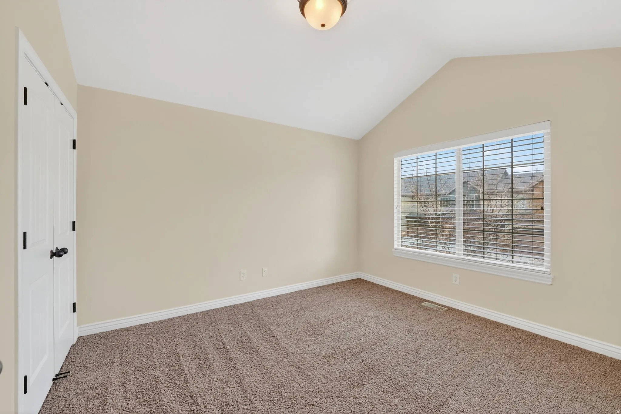 Spare room featuring carpet flooring and baseboards