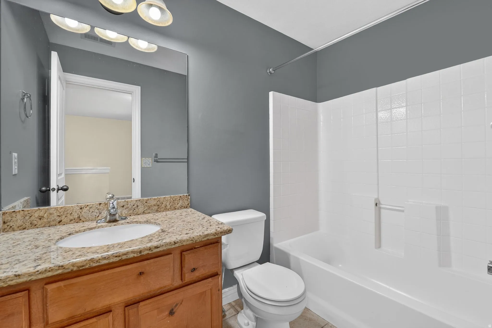 Full bathroom with vanity,  shower combination, and light tile patterned floors