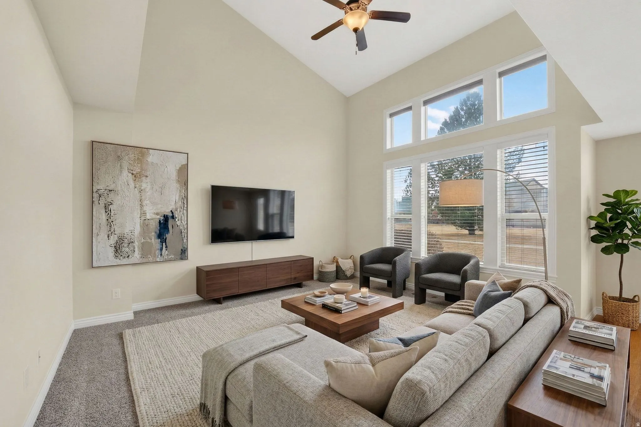 Living area with carpet floors, a ceiling fan, and lofted ceiling