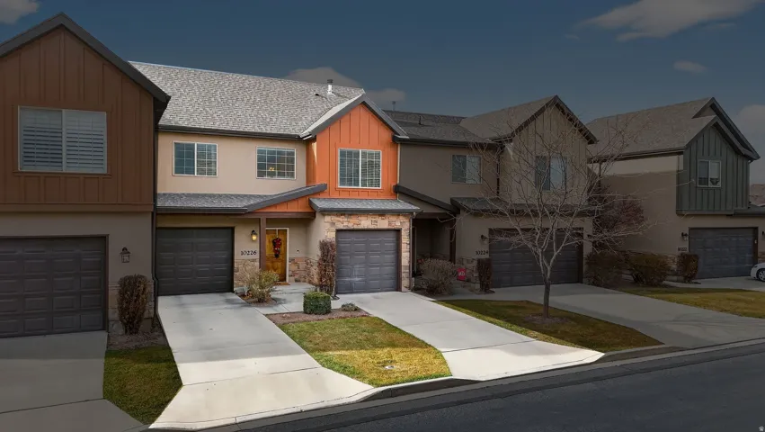 View of front of property featuring roof with shingles, concrete driveway, board and batten siding, and stucco siding