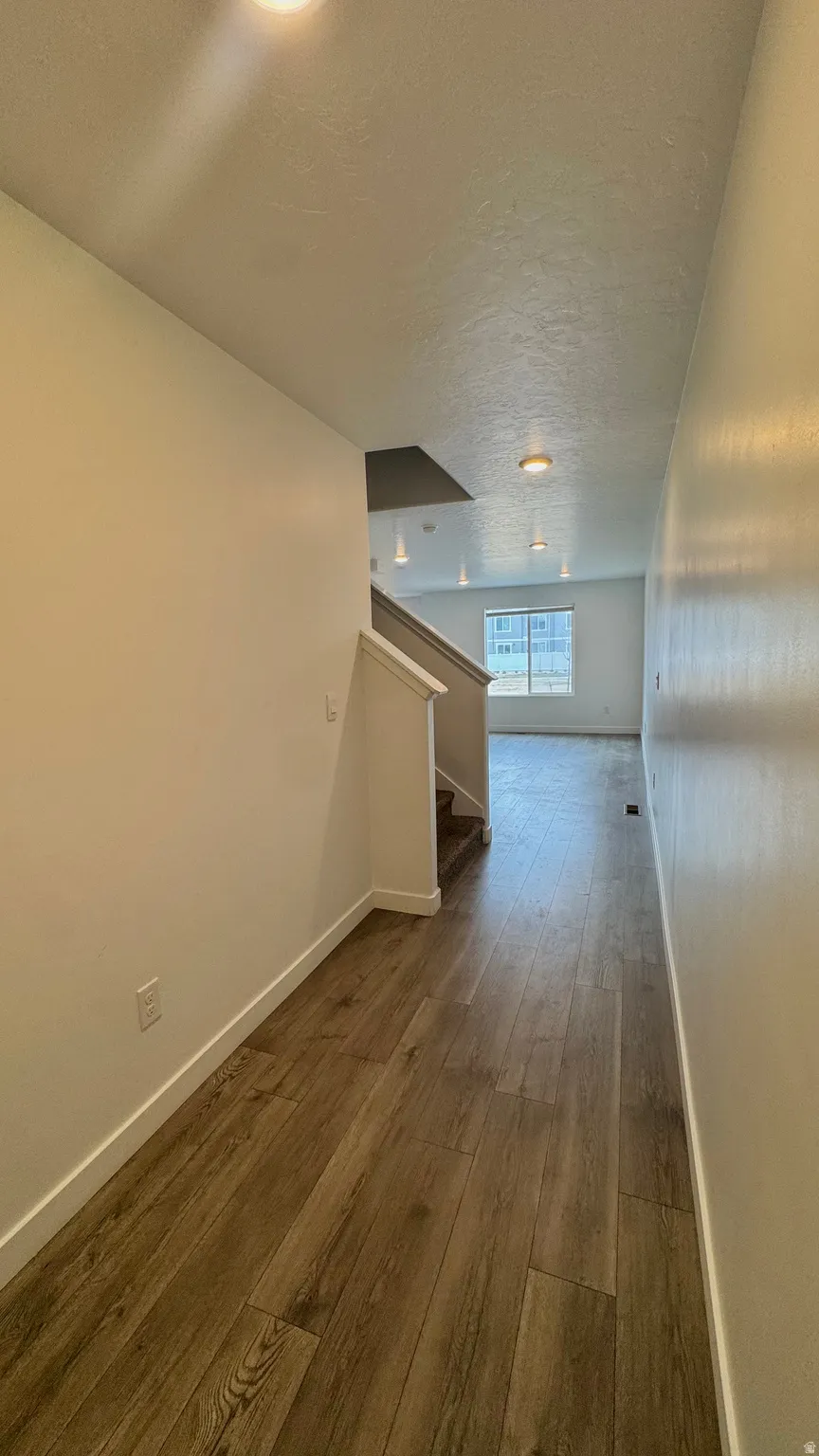 Hall with dark wood finished floors and a textured ceiling