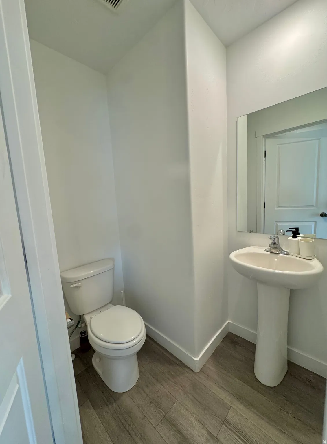 Bathroom featuring wood finished floors and toilet
