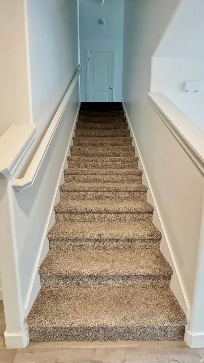 Stairs featuring wood finished floors and baseboards