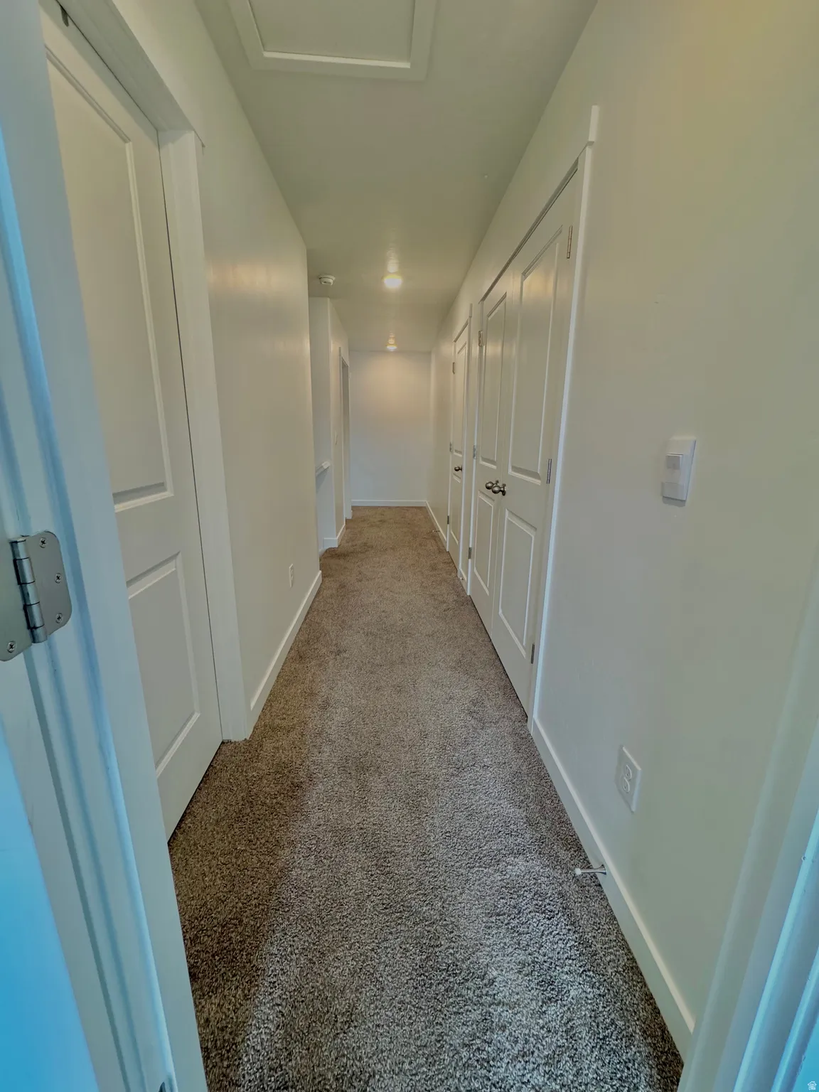 Corridor with baseboards and carpet