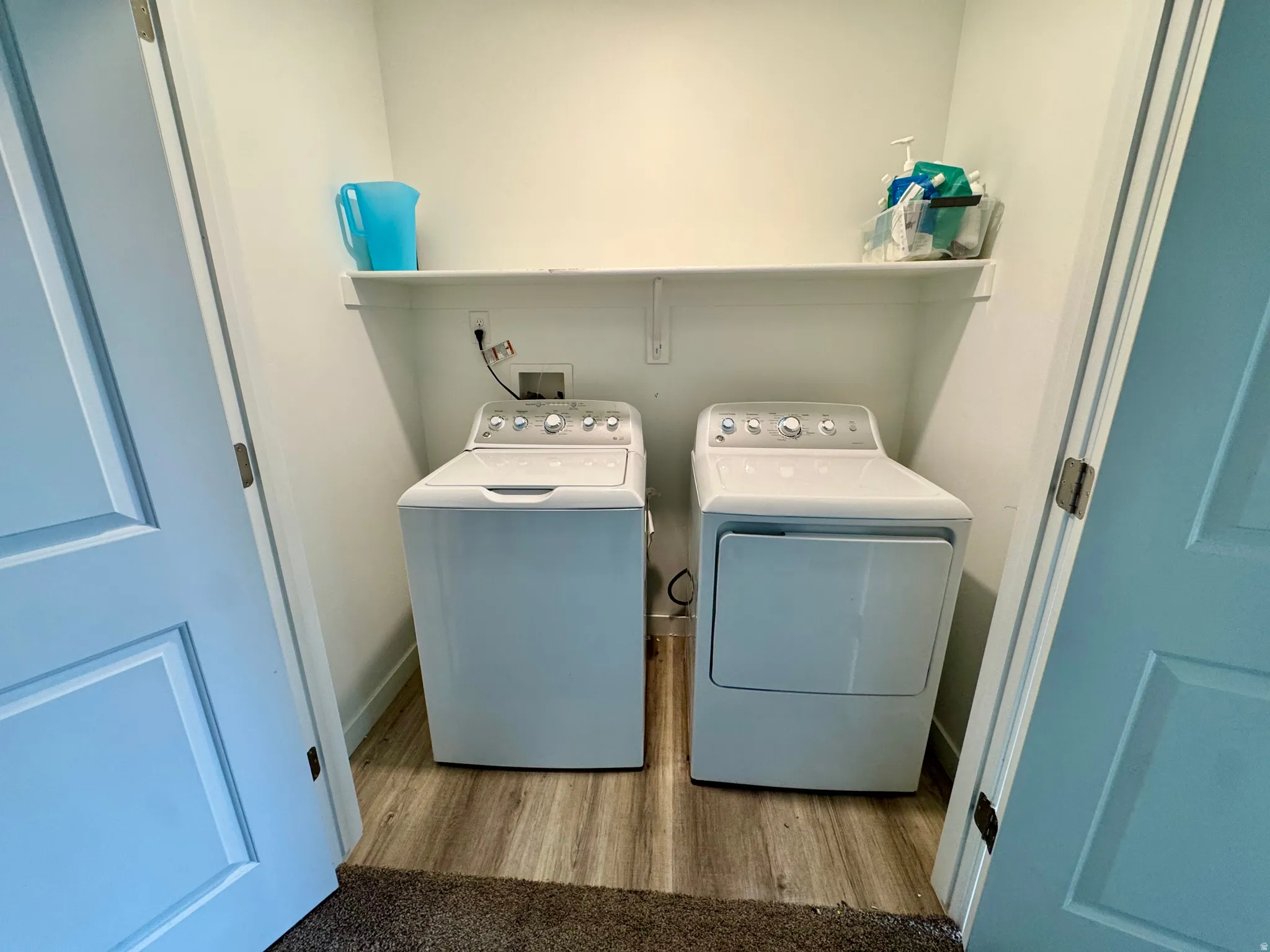 Laundry area featuring light wood-style floors and washing machine and clothes dryer