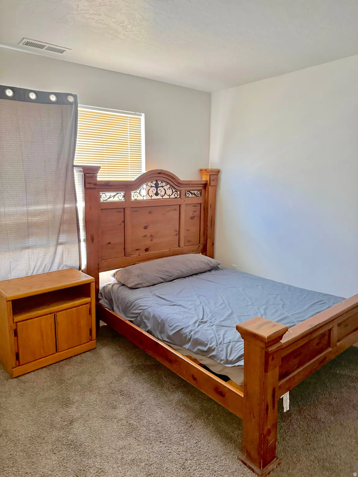 Carpeted bedroom with a textured ceiling