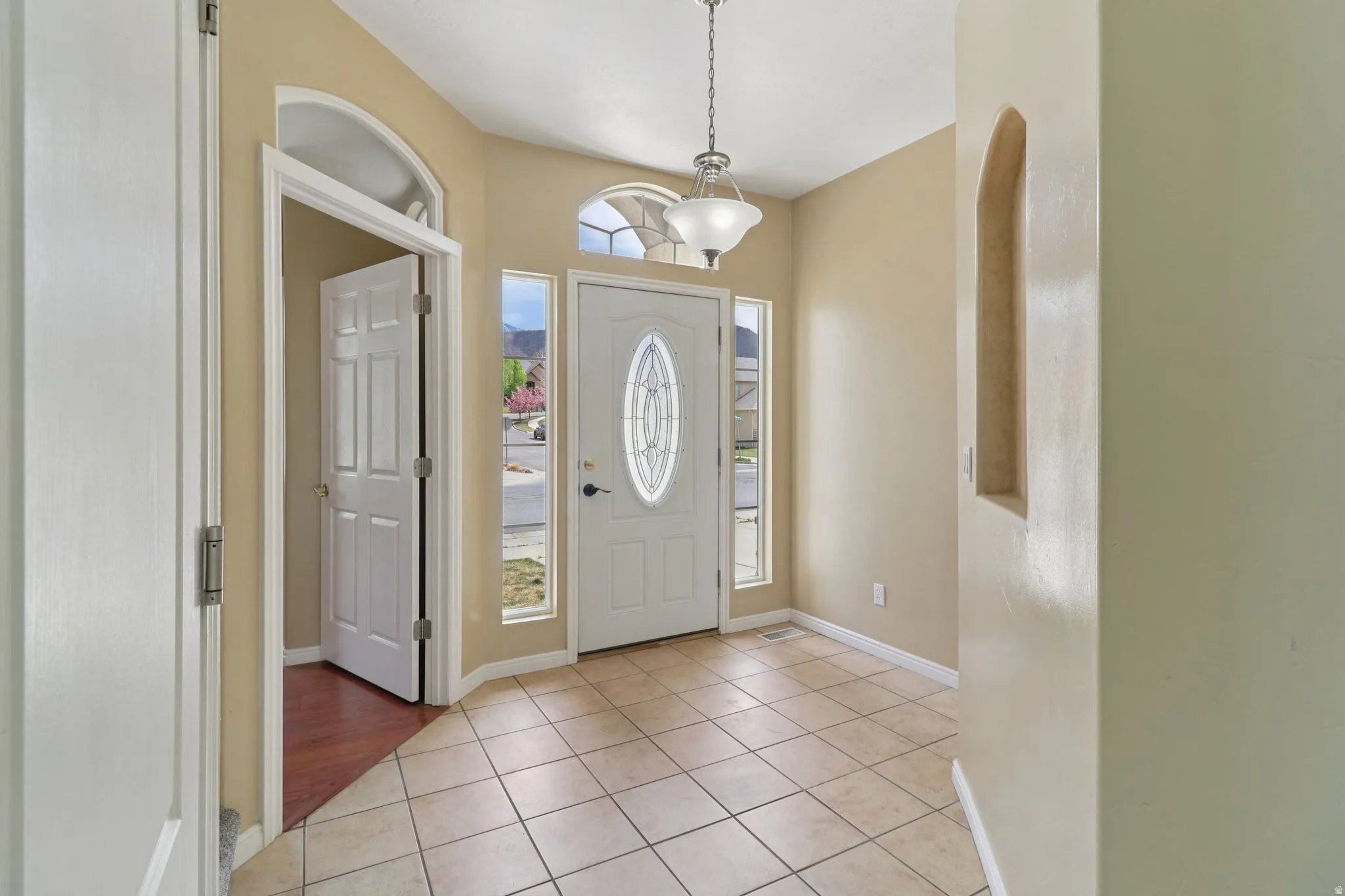 Foyer with light tile patterned flooring and arched walkways